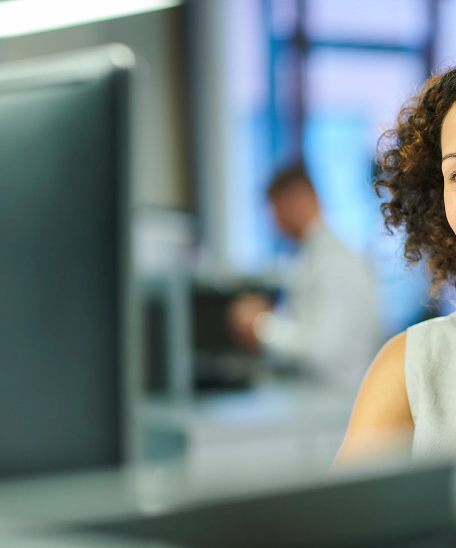 A smiling customer service representative wearing a headset, symbolising the transformation of claims settlement processes through digital solutions.