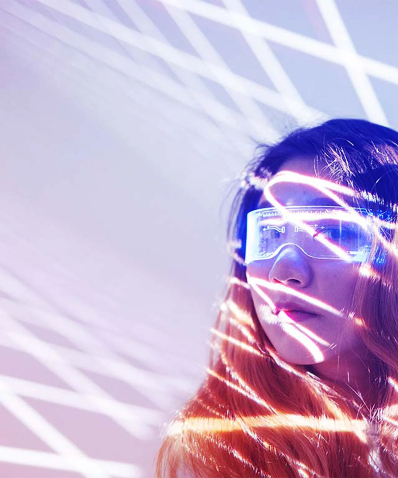 A woman wearing futuristic glasses illuminated by intersecting lines of light.