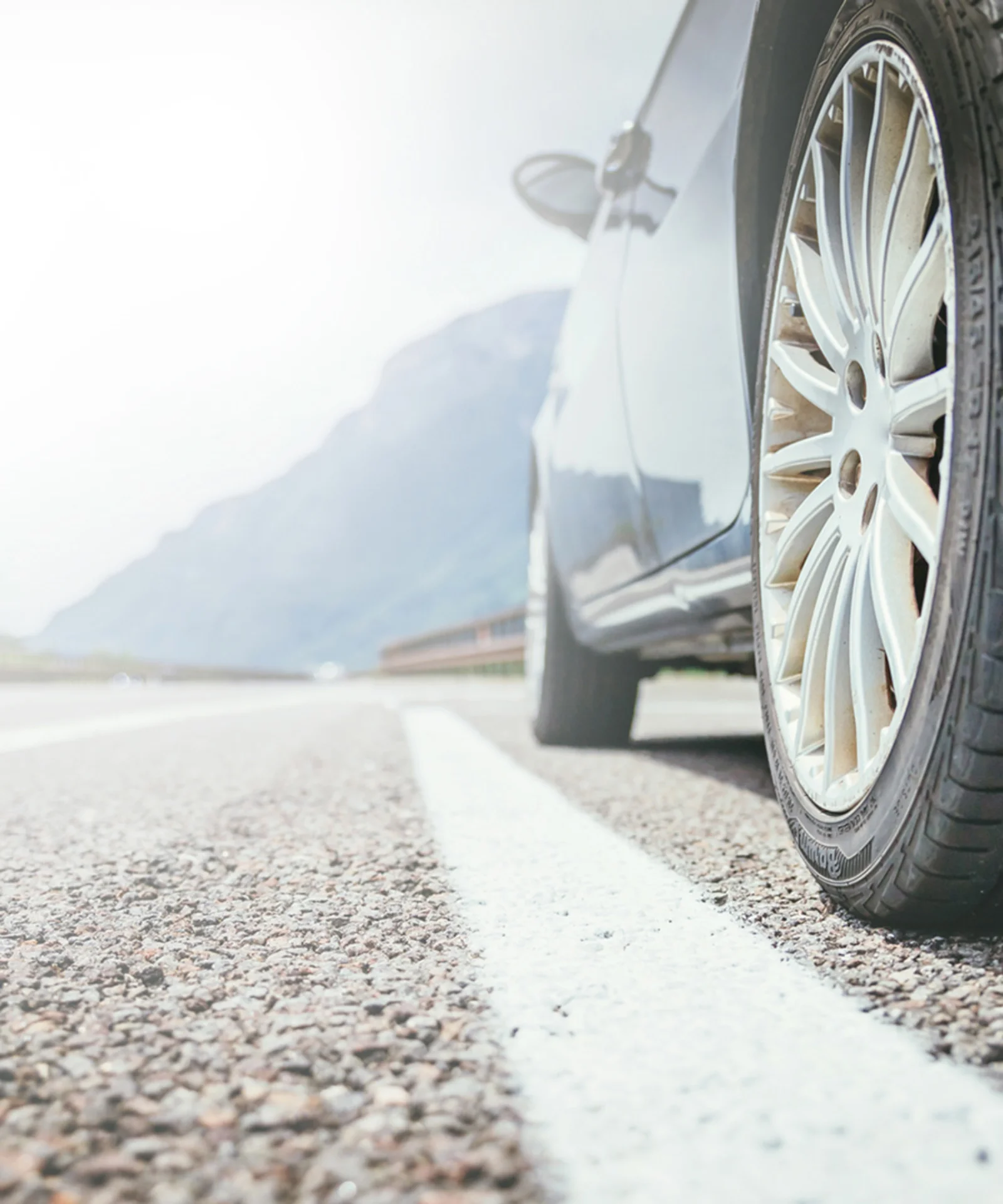 Close-up of a car wheel on an open road, symbolising the seamless process of searching, financing, and driving away with a new vehicle.