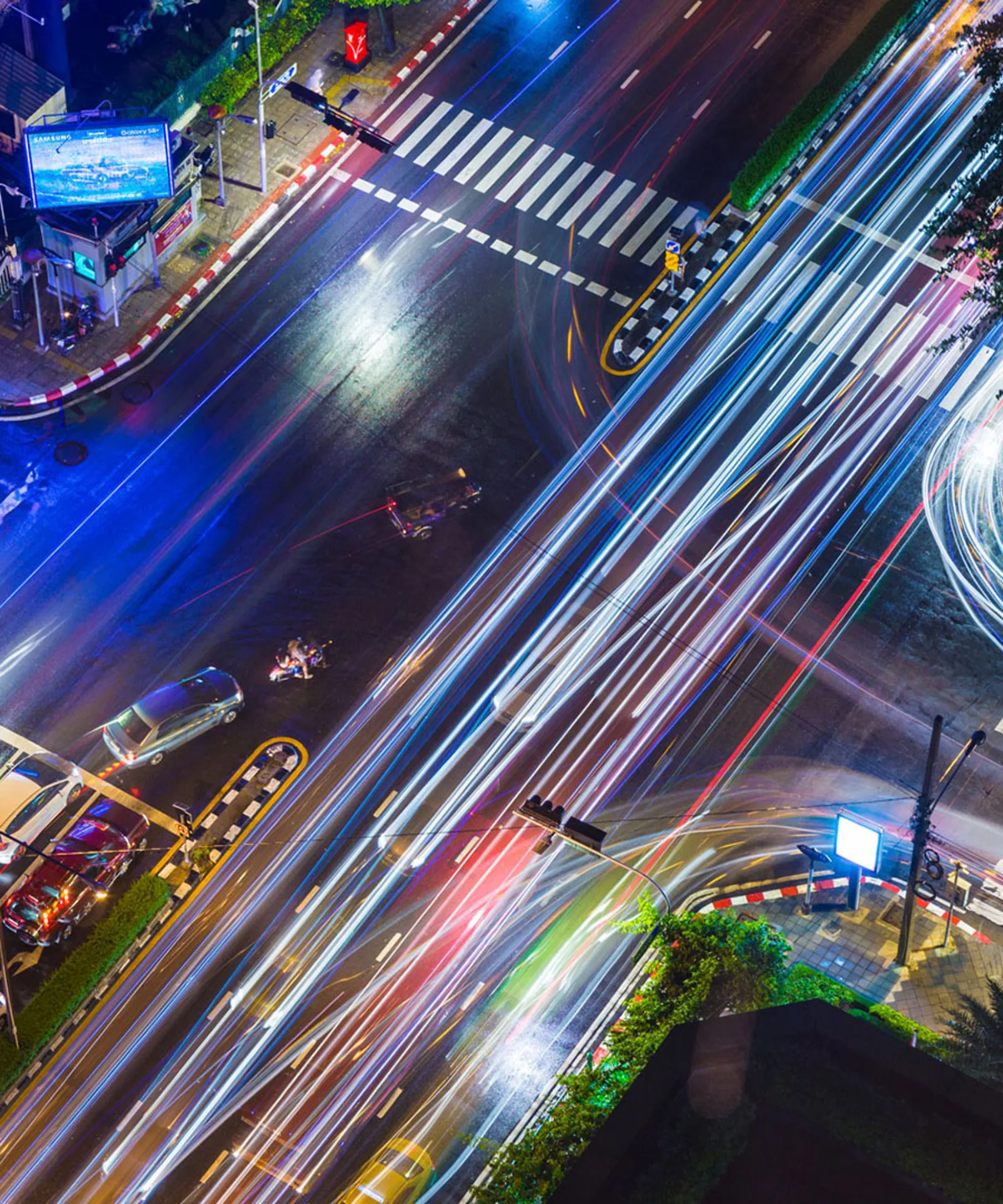 An aerial view of a busy city intersection at night, with streaks of light representing fast-moving traffic, symbolising the dynamic nature of personalised insurance solutions.