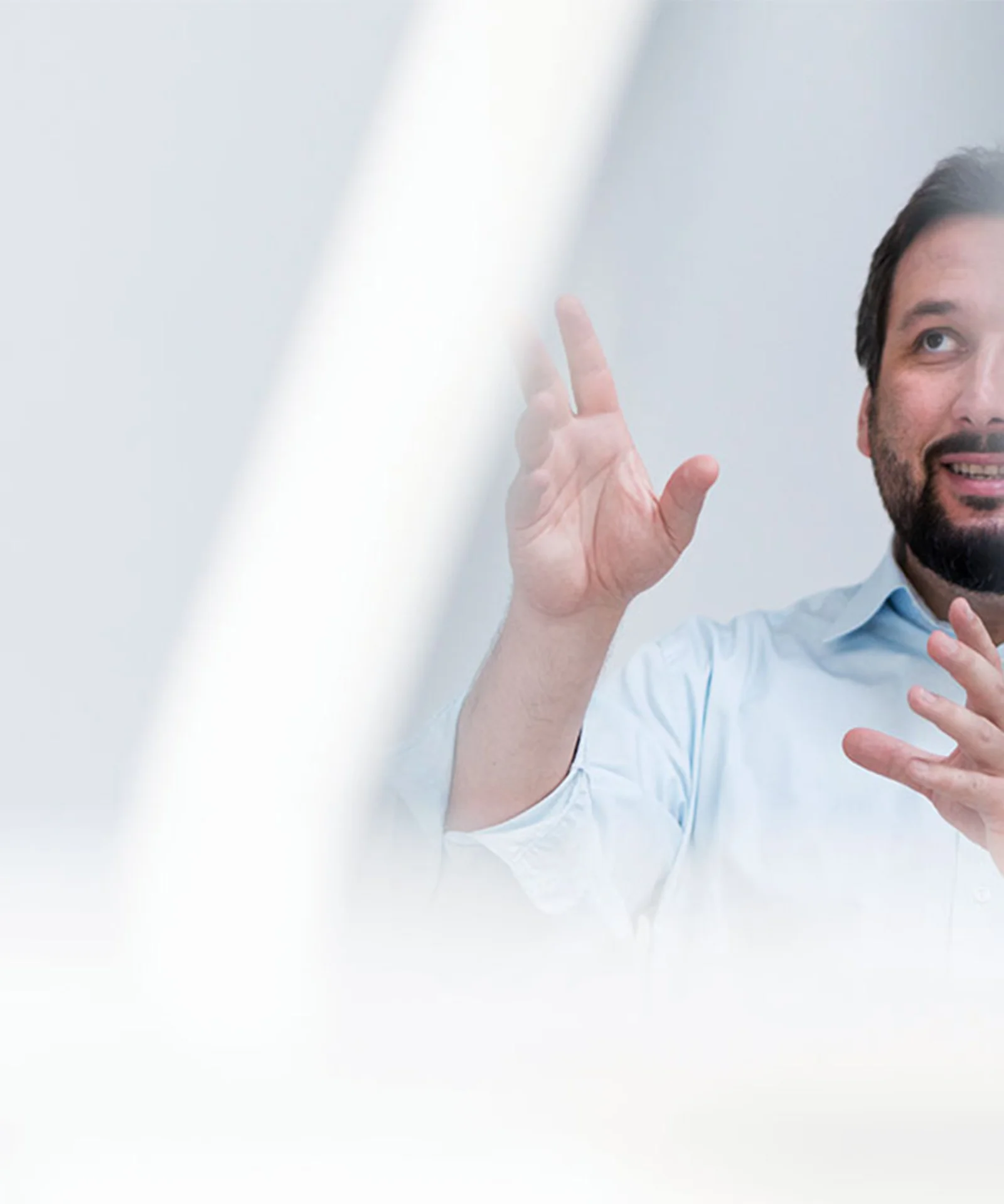 A man in a light blue shirt gestures while discussing ideas, symbolising thought leadership and innovation in the technology sector.