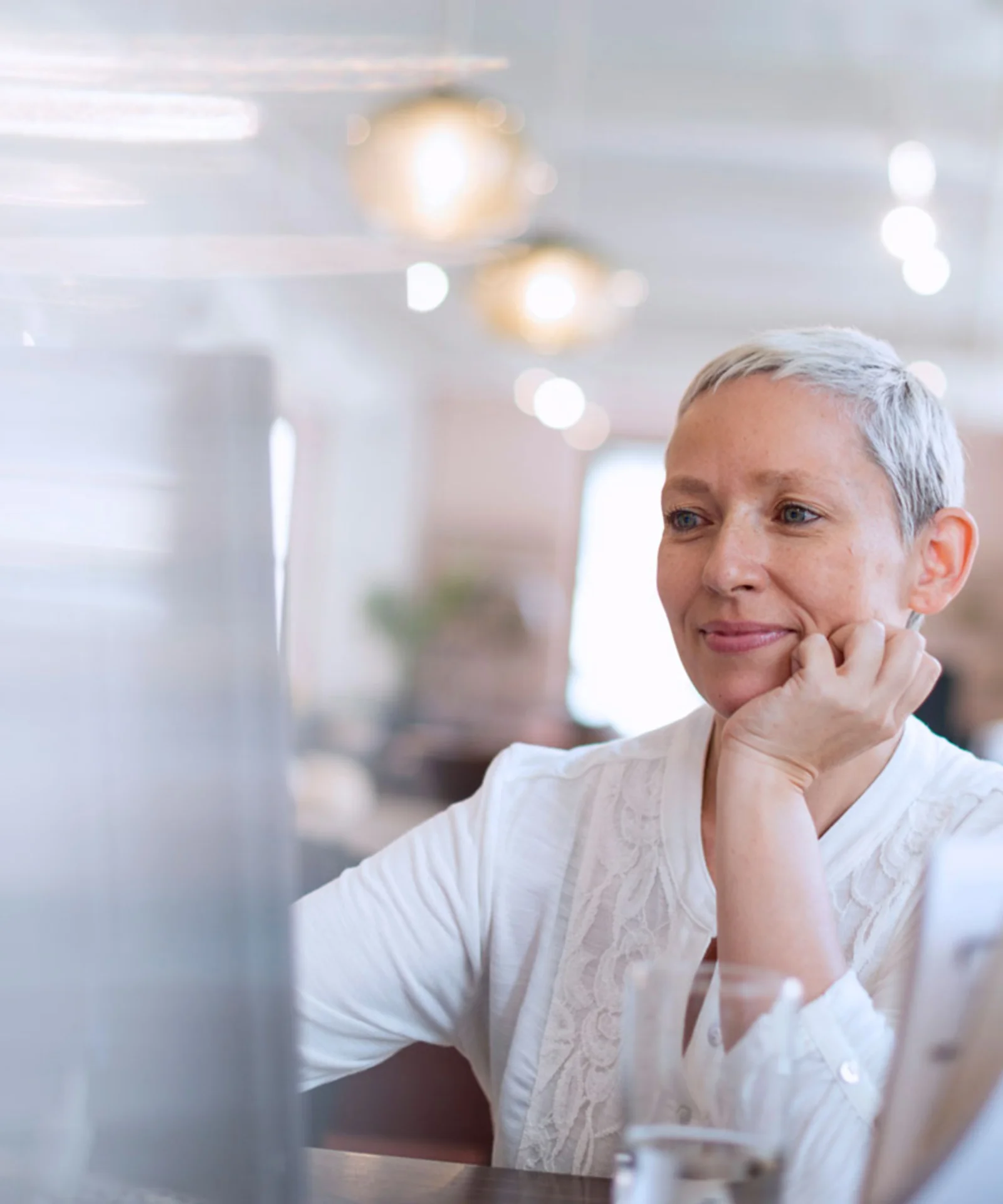 Smiling professional woman working at her desk in an office, representing the transformation of HR with AI chatbots.