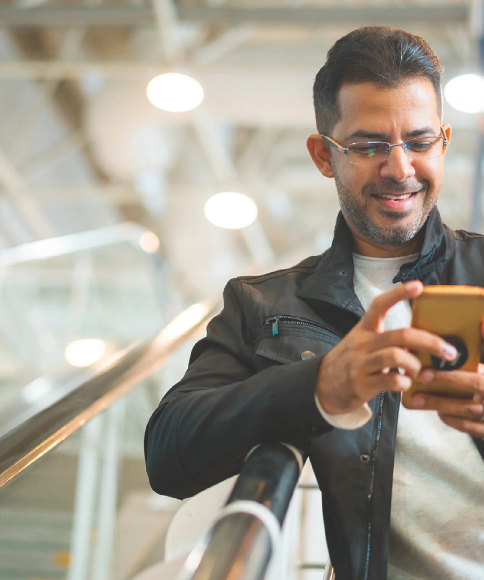 A man smiling while using his smartphone, representing the impact of banking disruption and modern digital services.