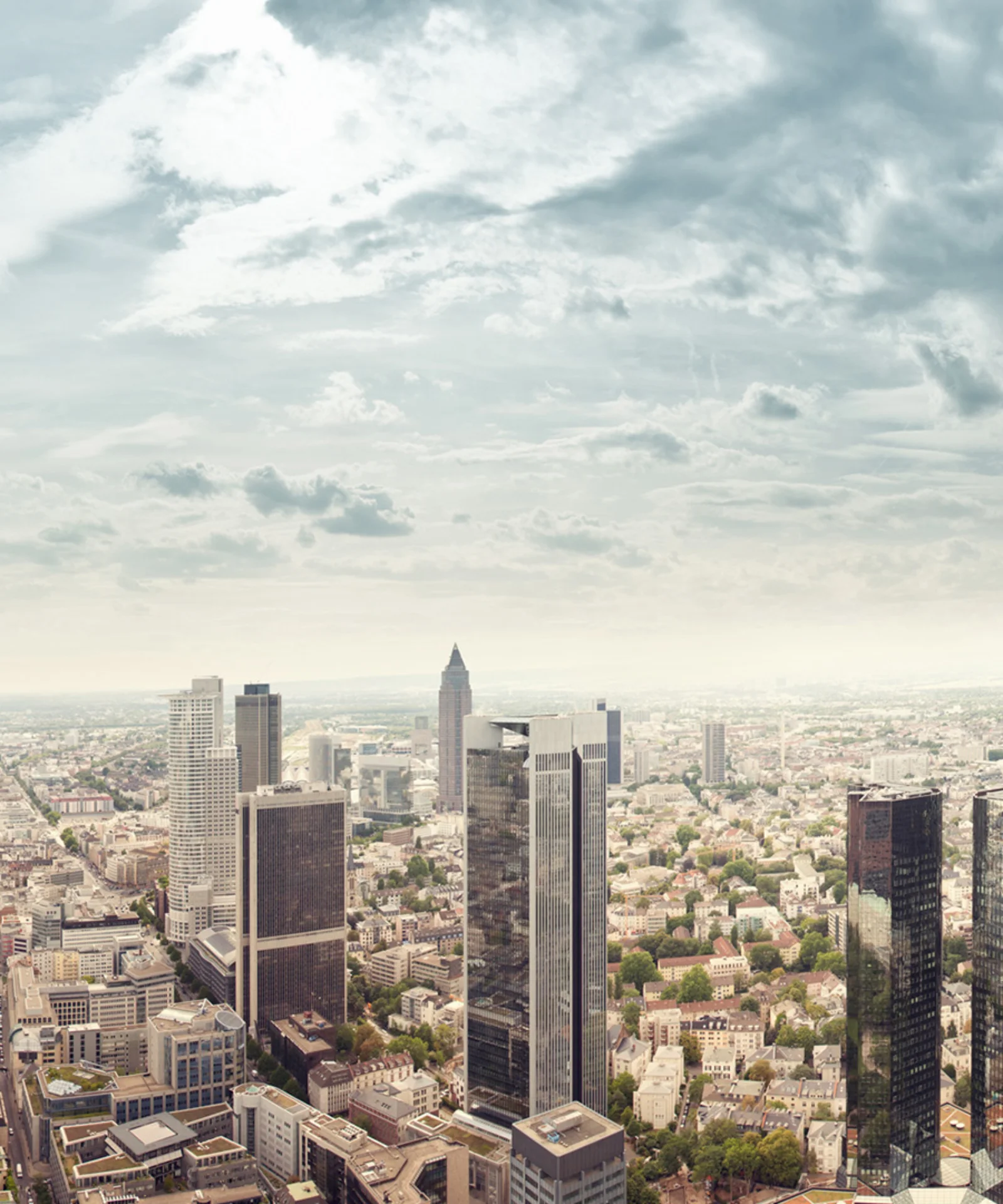 A panoramic view of a modern city skyline with towering buildings, representing DekaBank&#039;s replatforming journey with GFT.