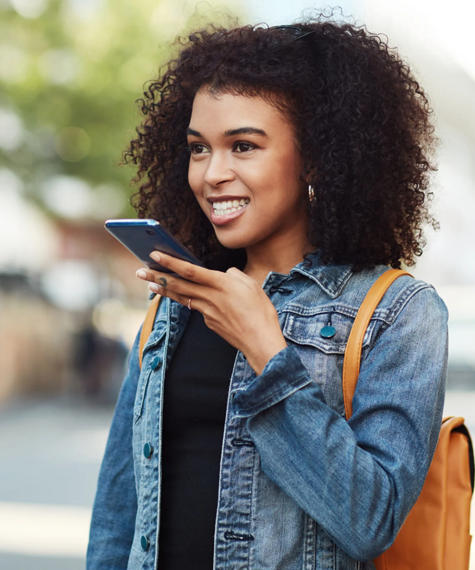 Una mujer joven que usa comandos de voz en su teléfono inteligente, lo que representa un servicio al cliente mejorado a través de la integración de Google Assistant.