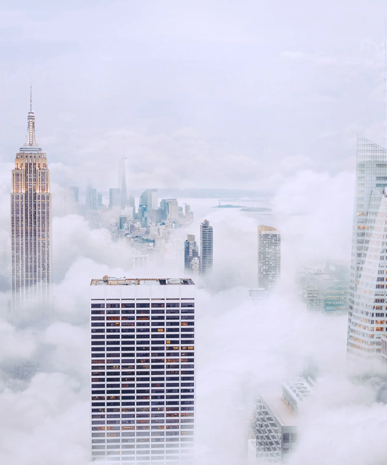 A breathtaking view of skyscrapers towering above the clouds in a misty cityscape, symbolising innovation and modern architecture.