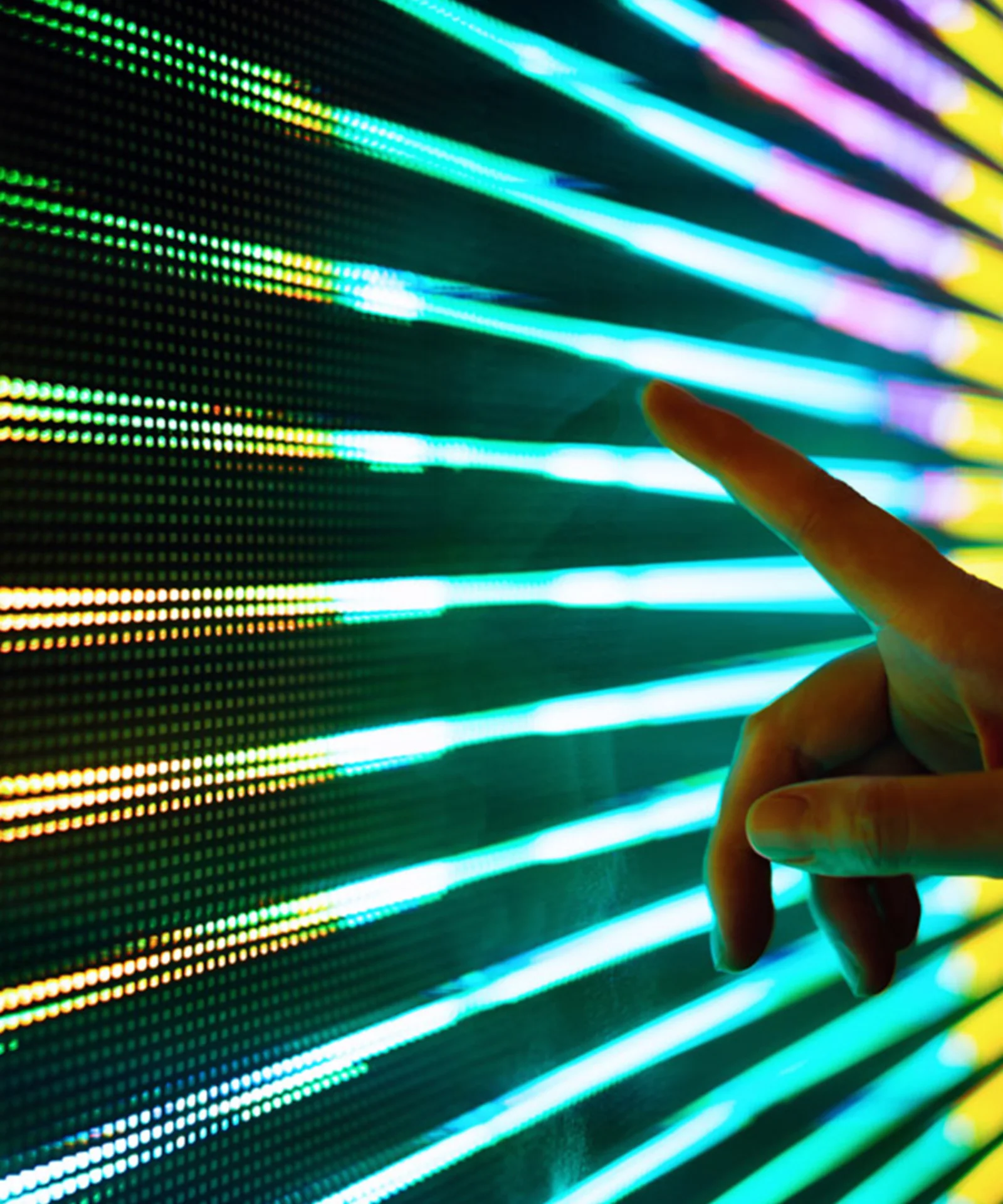 A hand interacting with a vibrant LED digital interface, showcasing dynamic data or light patterns.