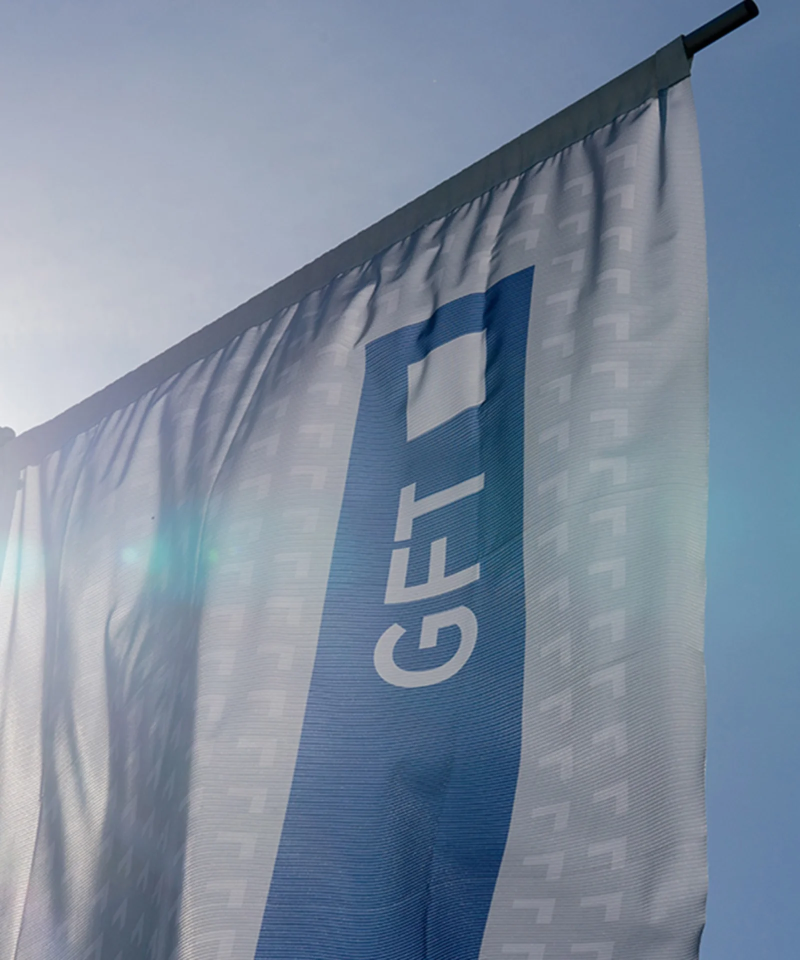 A GFT flag waving in the bright sunlight, symbolising the company&#039;s presence and commitment to excellence.