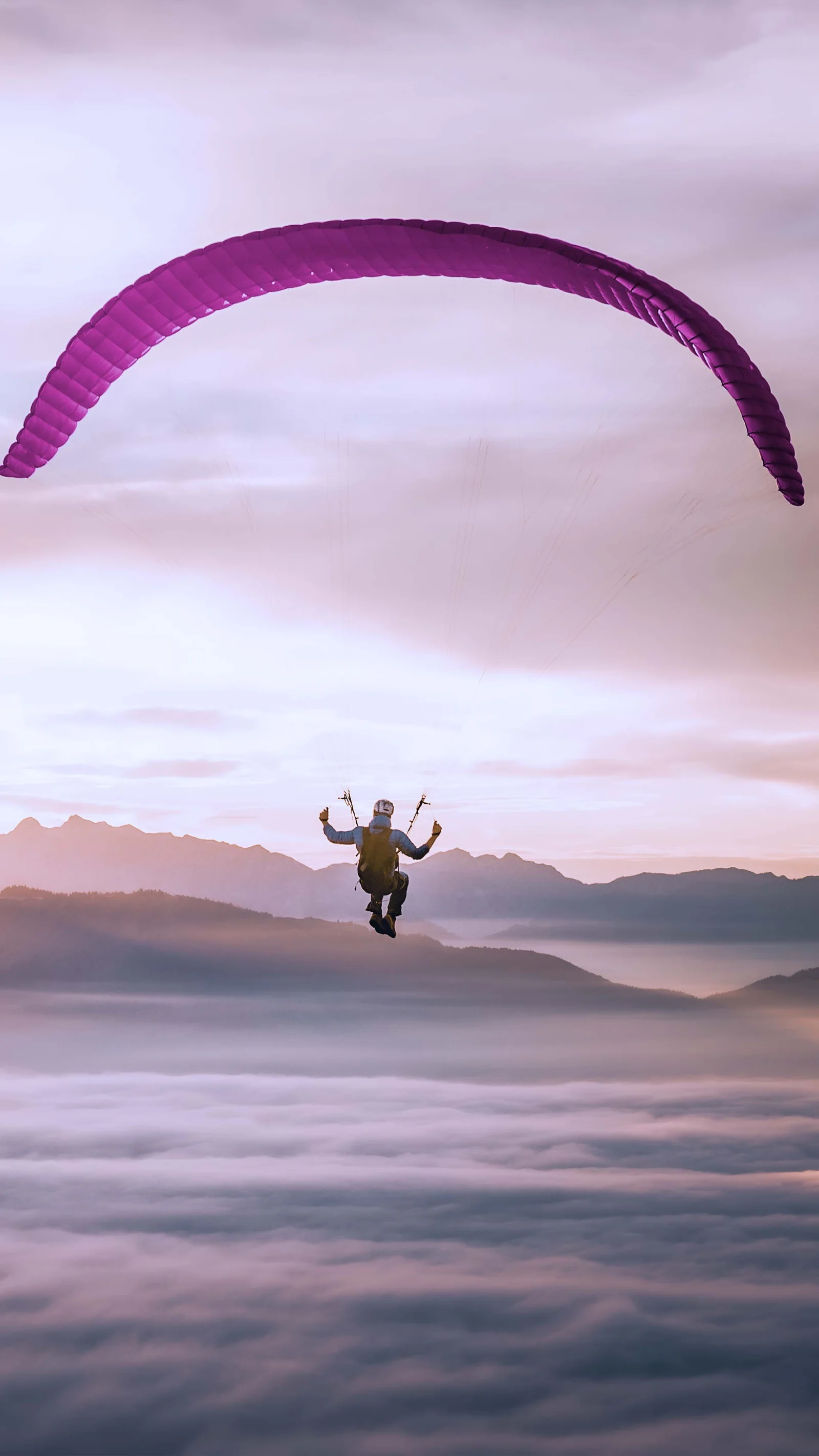 Ein Paraglider schwebt über den Wolken bei Sonnenaufgang, symbolisiert die Flexibilität und Freiheit in der Cloud-Nutzung, während gleichzeitig die Kontrolle über Kosten erhalten bleibt.