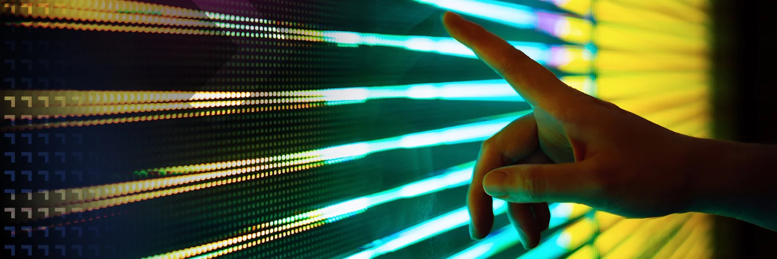 Close-up of a hand reaching out to interact with a vibrant LED light display, symbolizing the connection between technology and human interaction.