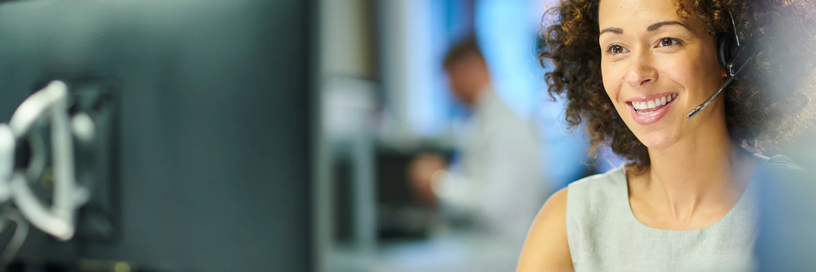 A smiling customer service representative wearing a headset, symbolising the transformation of claims settlement processes through digital solutions.