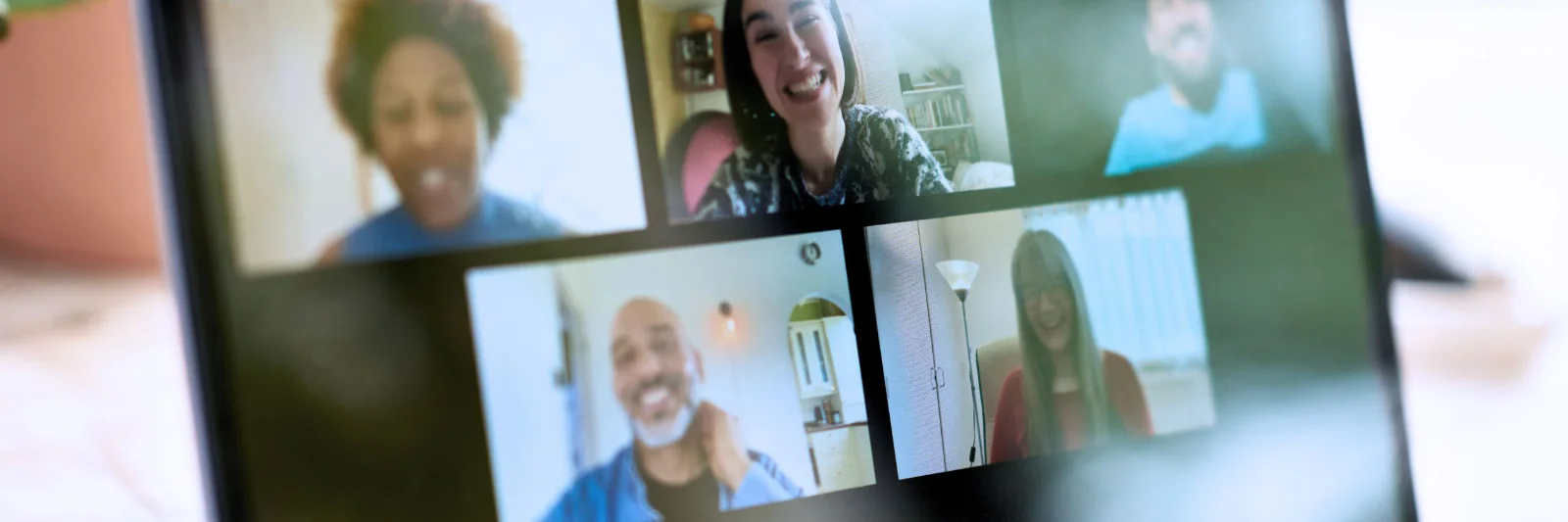 Laptop screen showing a group of diverse people participating in a video conference, representing remote collaboration and virtual teamwork.