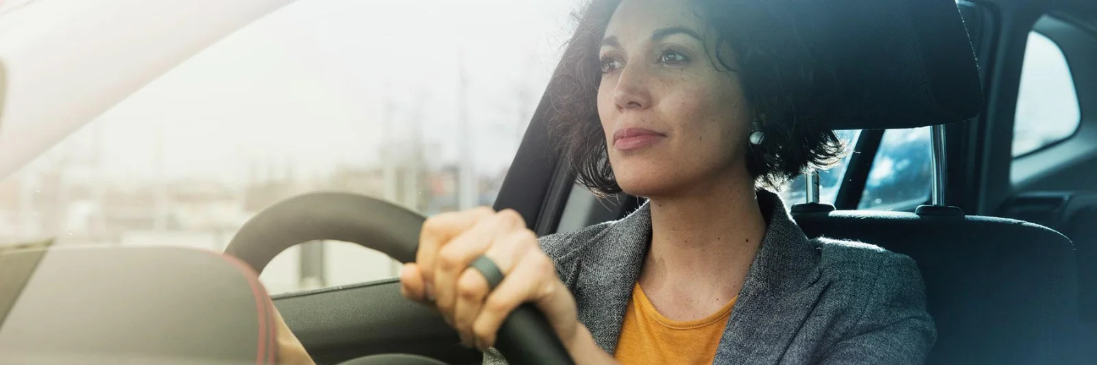 A focused woman driving a car, symbolising the journey of modernisation and innovation in the insurance sector.