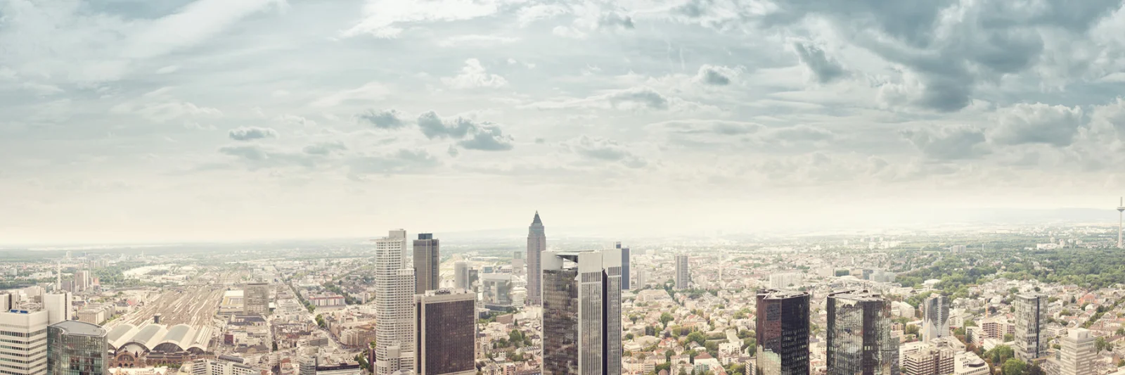 Ein Panoramablick auf die Skyline einer modernen Stadt mit hoch aufragenden Gebäuden, die den Replatforming-Prozess der DekaBank mit GFT darstellen.