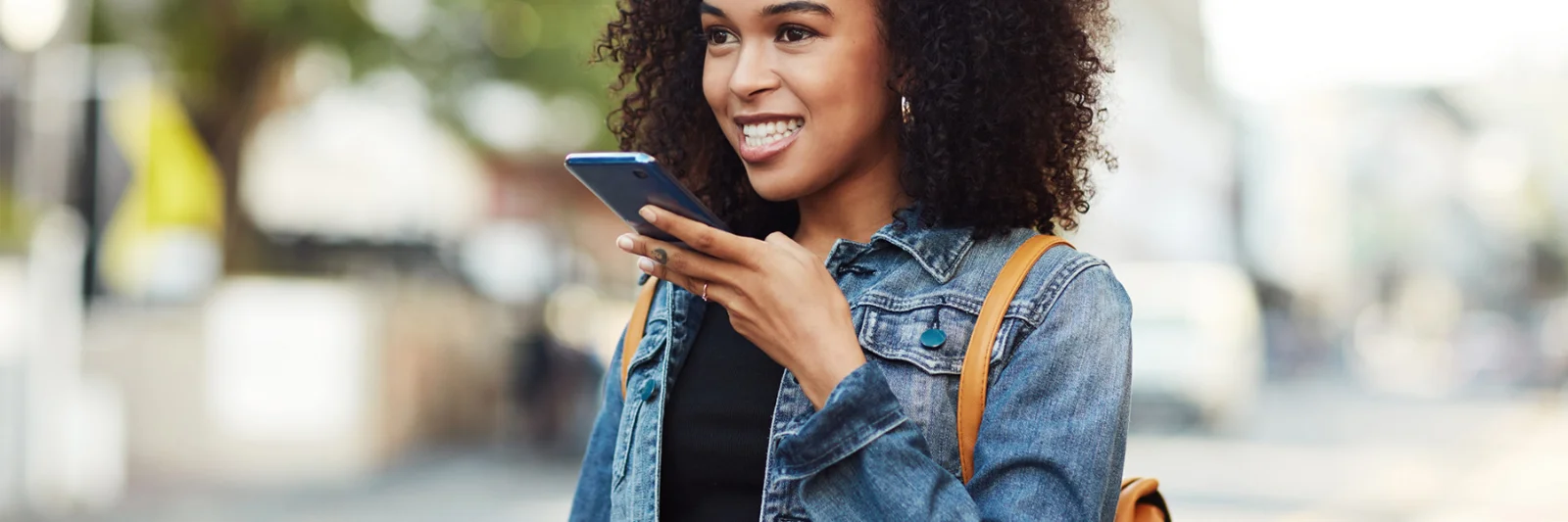 A young woman using voice commands on her smartphone, representing enhanced customer service through Google Assistant integration.