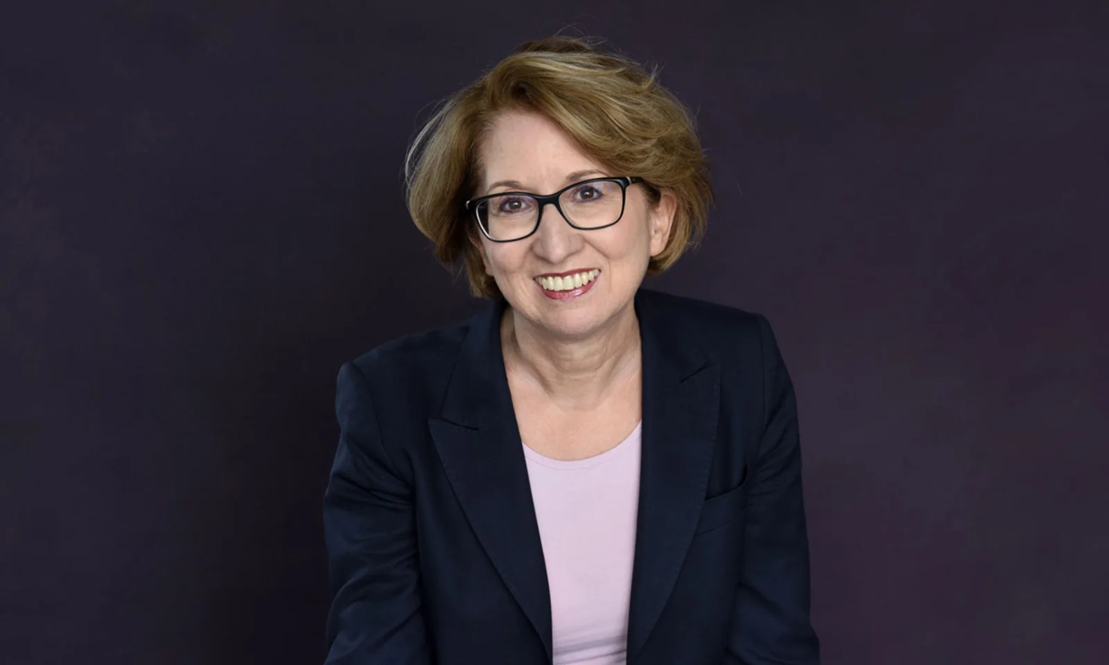 Professional portrait of Maria Dietz, Member of the Administrative Board, against a dark background