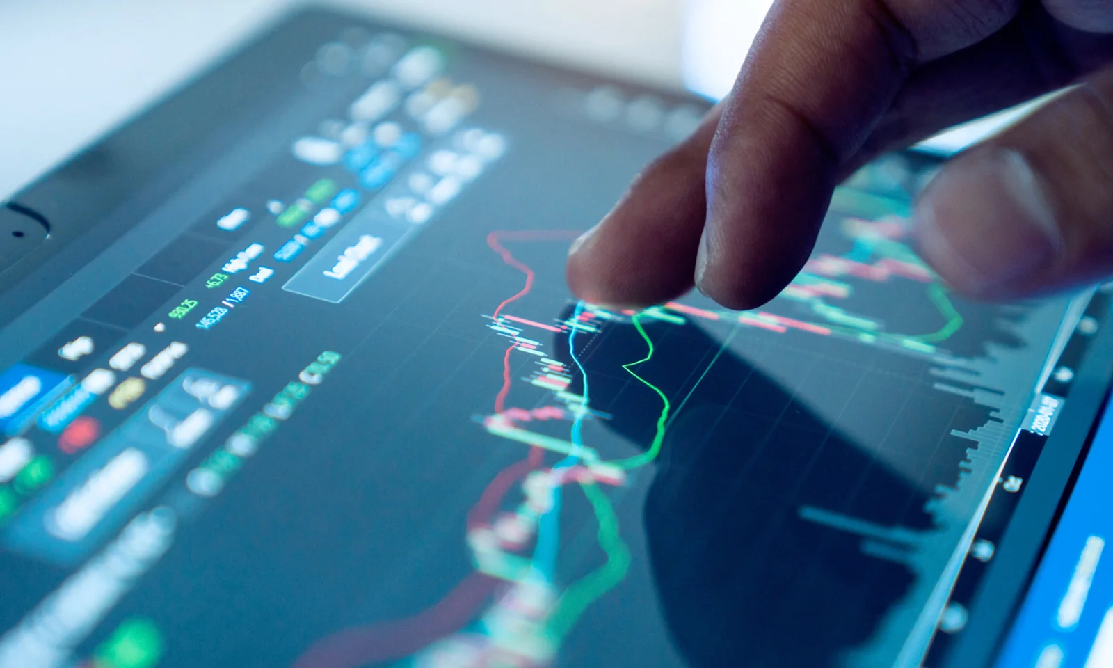 Close-up of a hand interacting with a digital graph on a touchscreen device, displaying energy load management data.