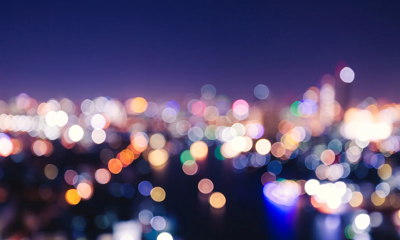 A vibrant, blurred cityscape at night, symbolising the dynamic and personalised nature of modern insurance solutions.