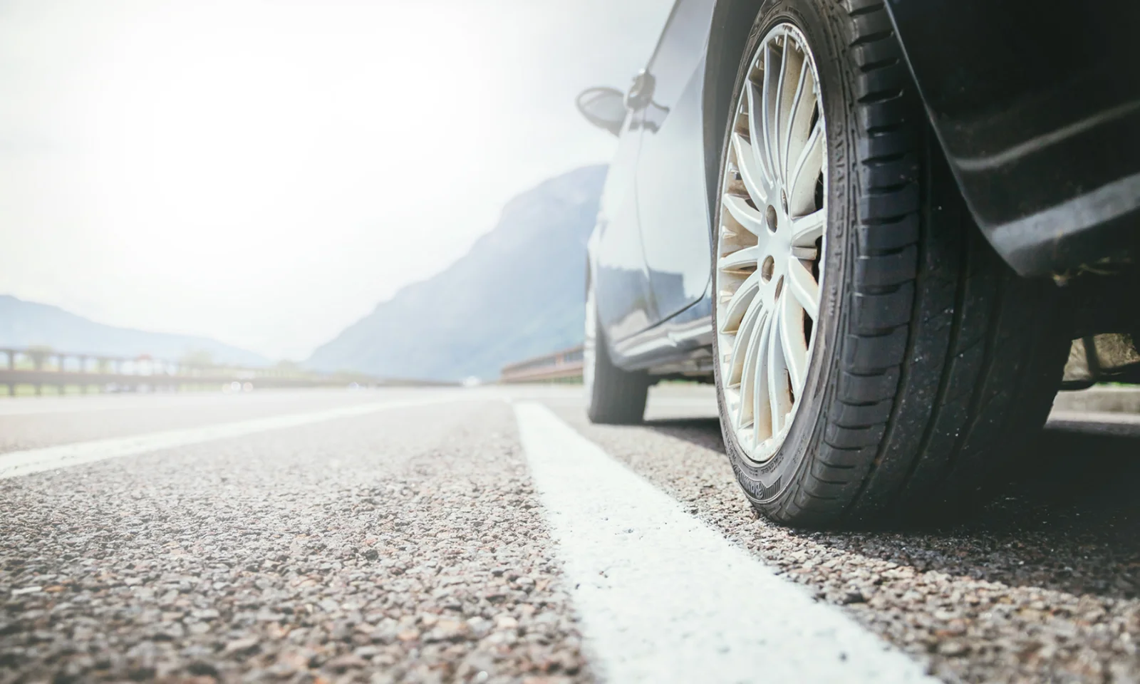 Close-up of a car wheel on an open road, symbolising the seamless process of searching, financing, and driving away with a new vehicle.