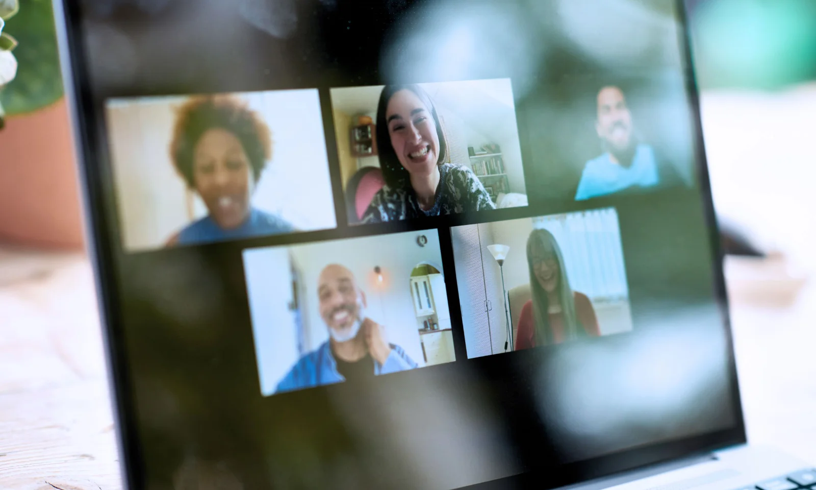 Laptop screen showing a group of diverse people participating in a video conference, representing remote collaboration and virtual teamwork.