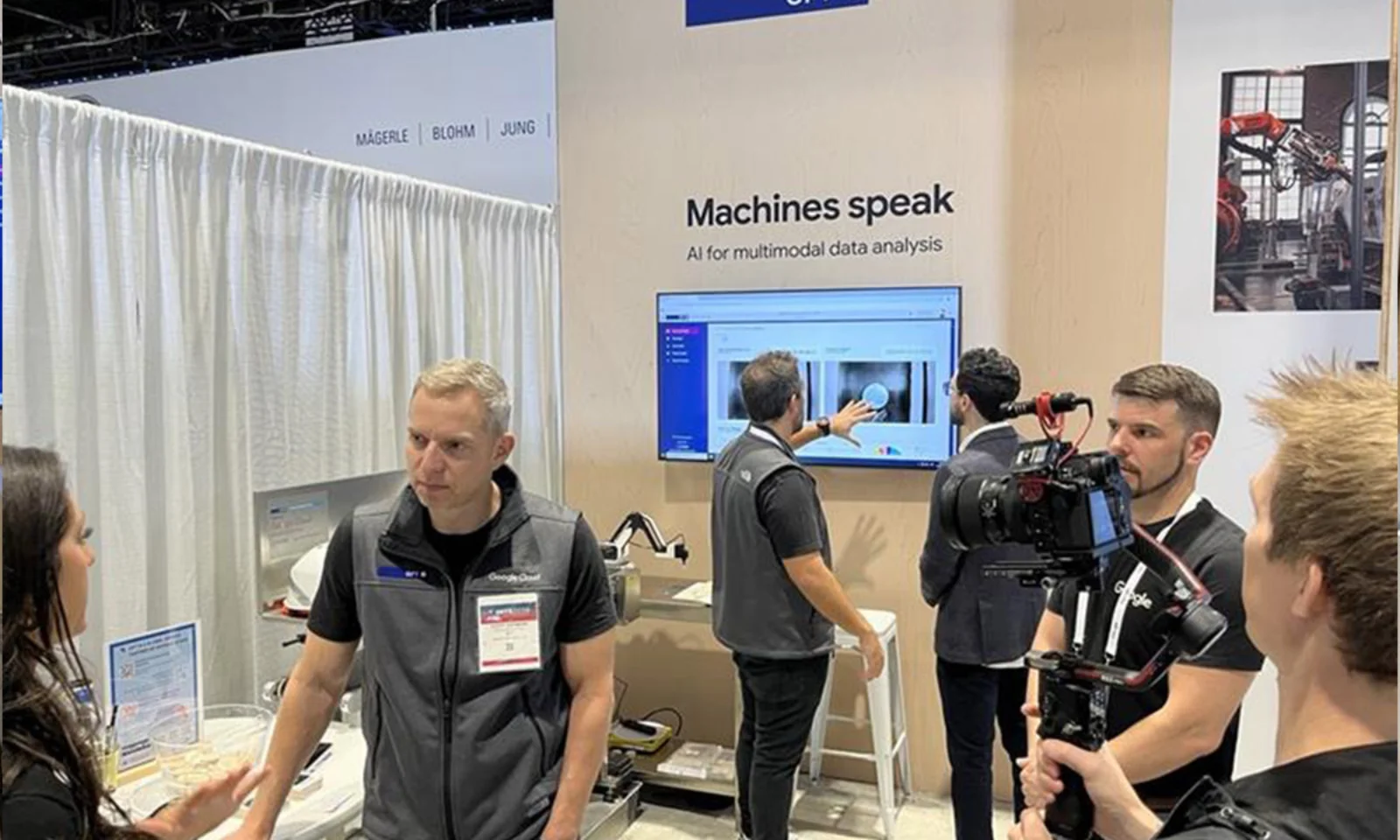 GFT booth at an industry event showcasing AI-driven multimodal data analysis, with experts demonstrating technology on a screen while attendees engage in discussions and a videographer captures the demonstration.