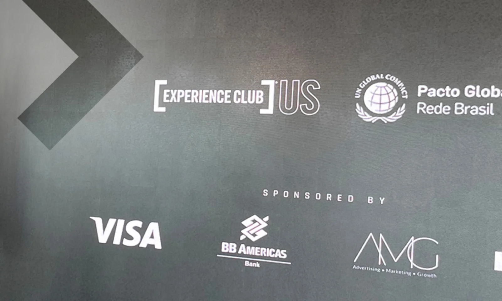 Corporate event banner displaying the logos of sponsors including Visa, BB Americas, AMG, and GFT, along with the Pacto Global Rede Brasil and Experience Club branding. Brazilian flags are visible in the background.