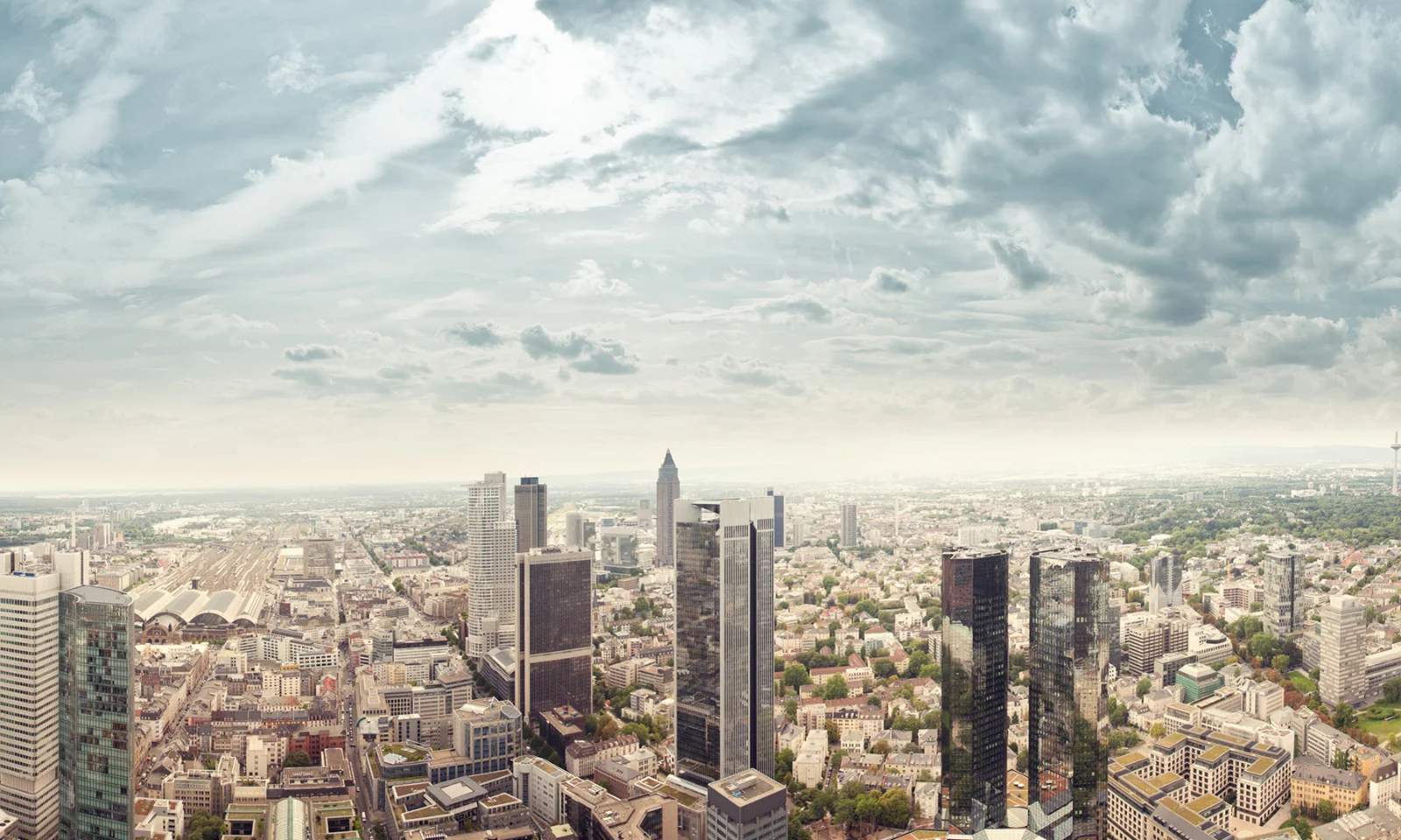 A panoramic view of a modern city skyline with towering buildings, representing DekaBank&#039;s replatforming journey with GFT.