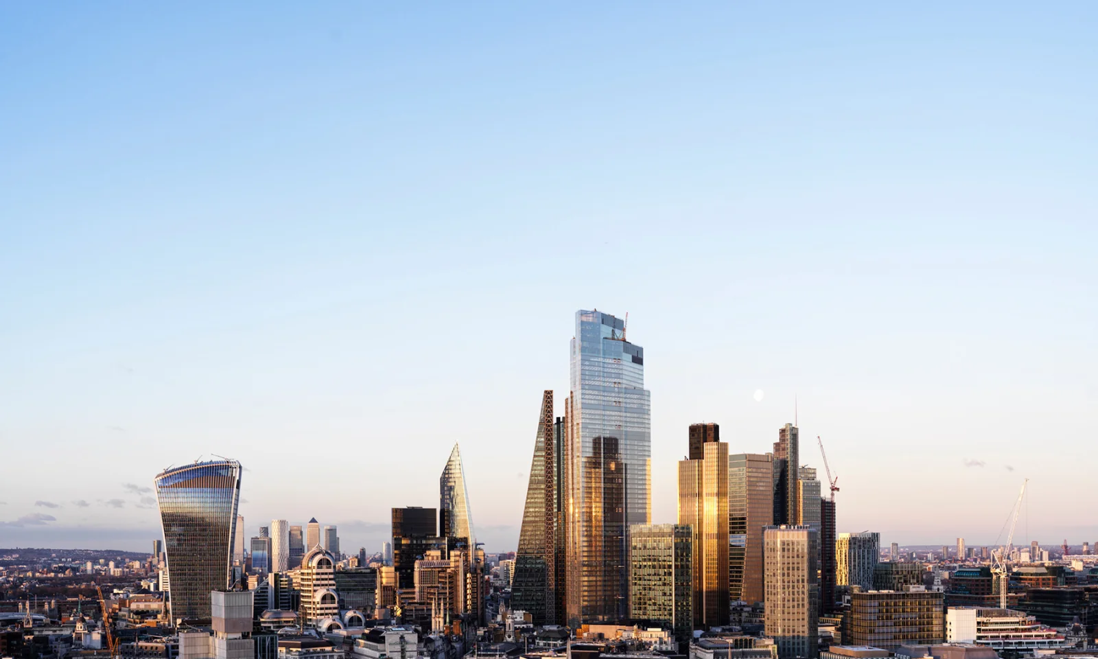 Skyline of modern skyscrapers at sunset with clear skies.