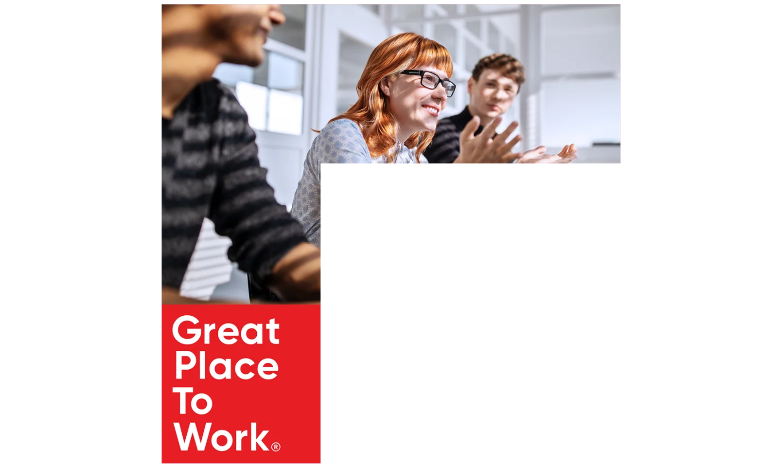 A group of professionals engaging in a lively discussion, highlighting the collaborative and positive work environment at a company recognised as a &quot;Great Place to Work.&quot;