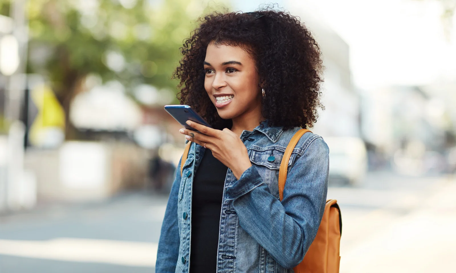 Una mujer joven que usa comandos de voz en su teléfono inteligente, lo que representa un servicio al cliente mejorado a través de la integración de Google Assistant.