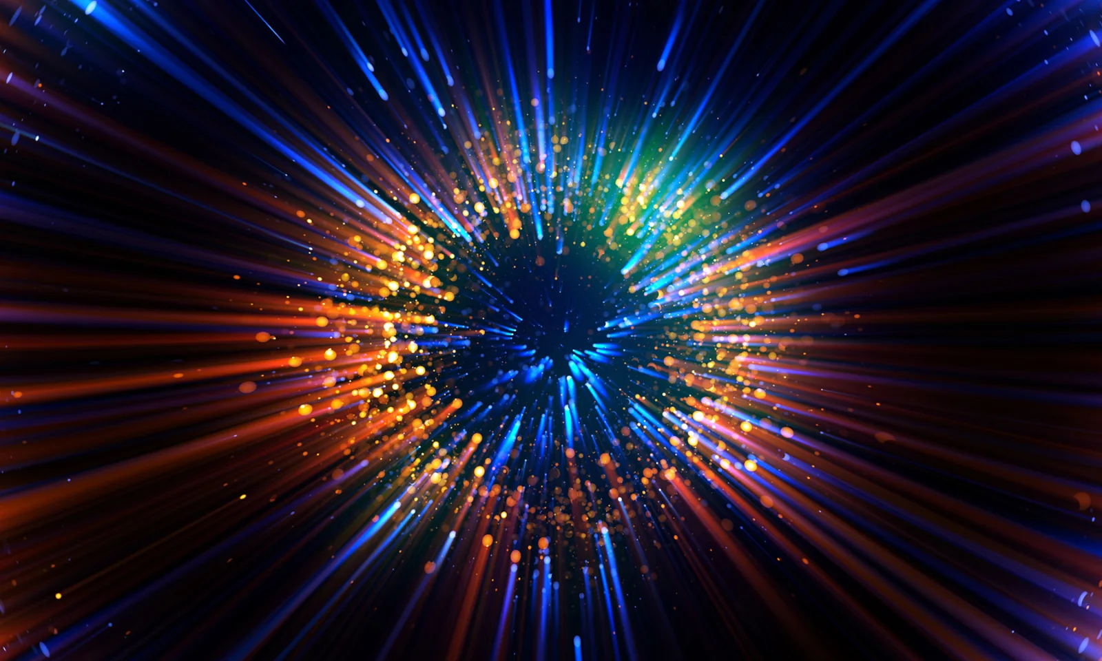 Abstract explosion of colourful light rays and particles against a dark background.