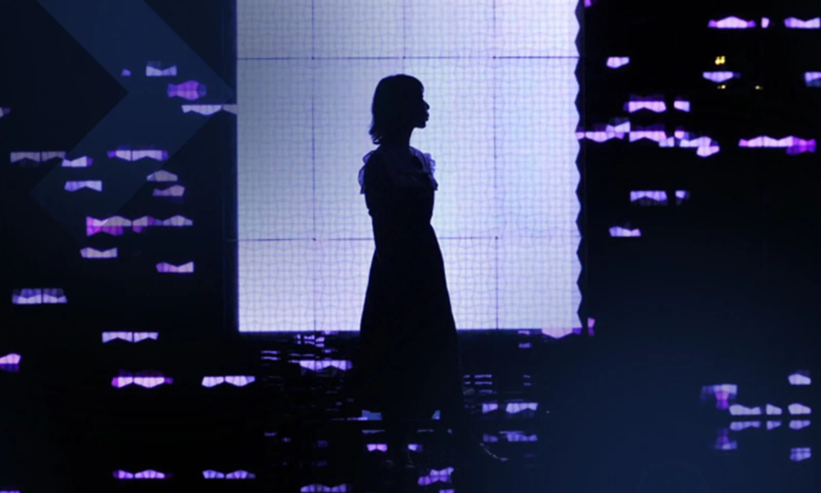 Silhouette of a person standing against a background of digital lights and screens, representing the intersection of technology and human presence in a digital world.