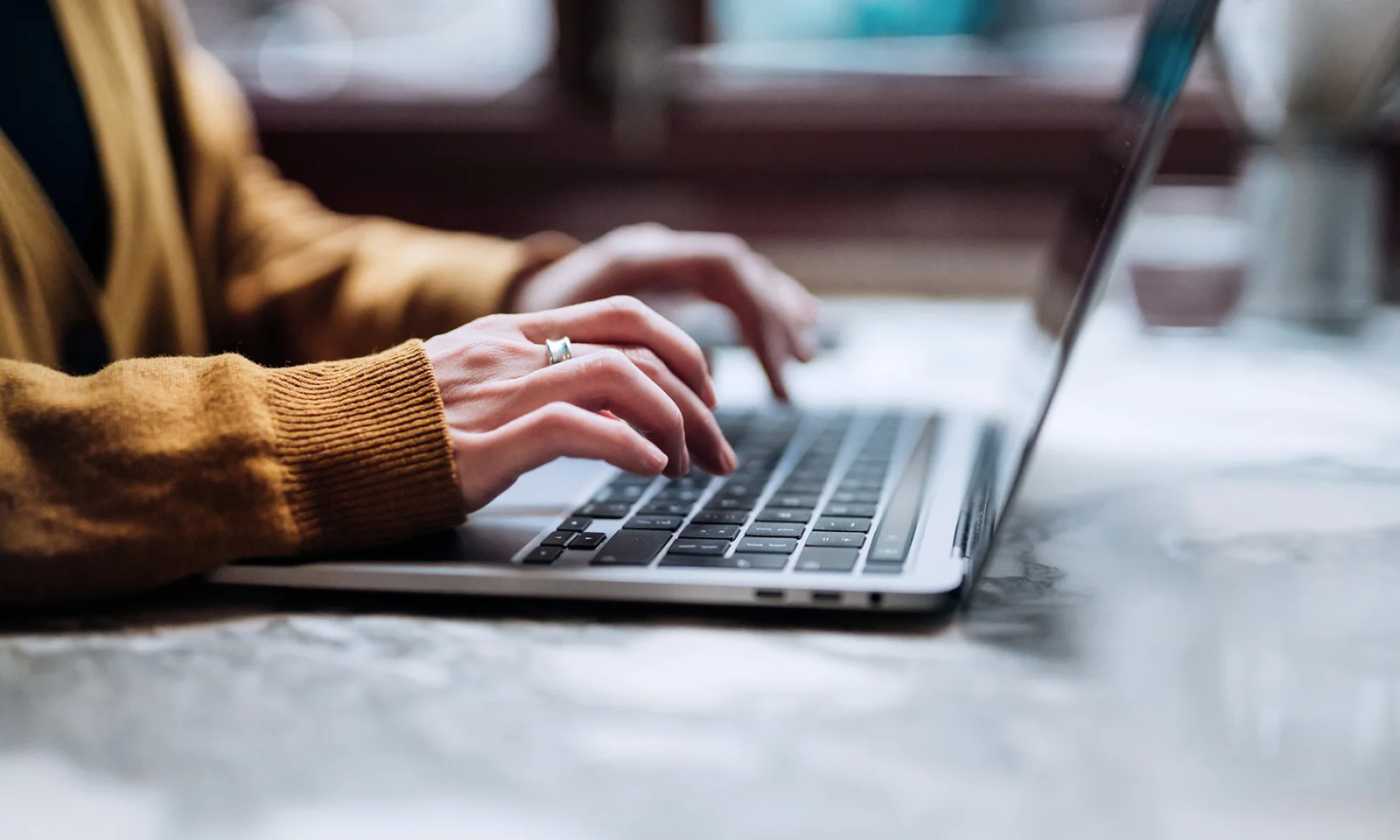 Uma pessoa digitando em um teclado de laptop, simbolizando o envolvimento e a interação com o ChatGPT, representando comunicação e assistência modernas baseadas em IA.