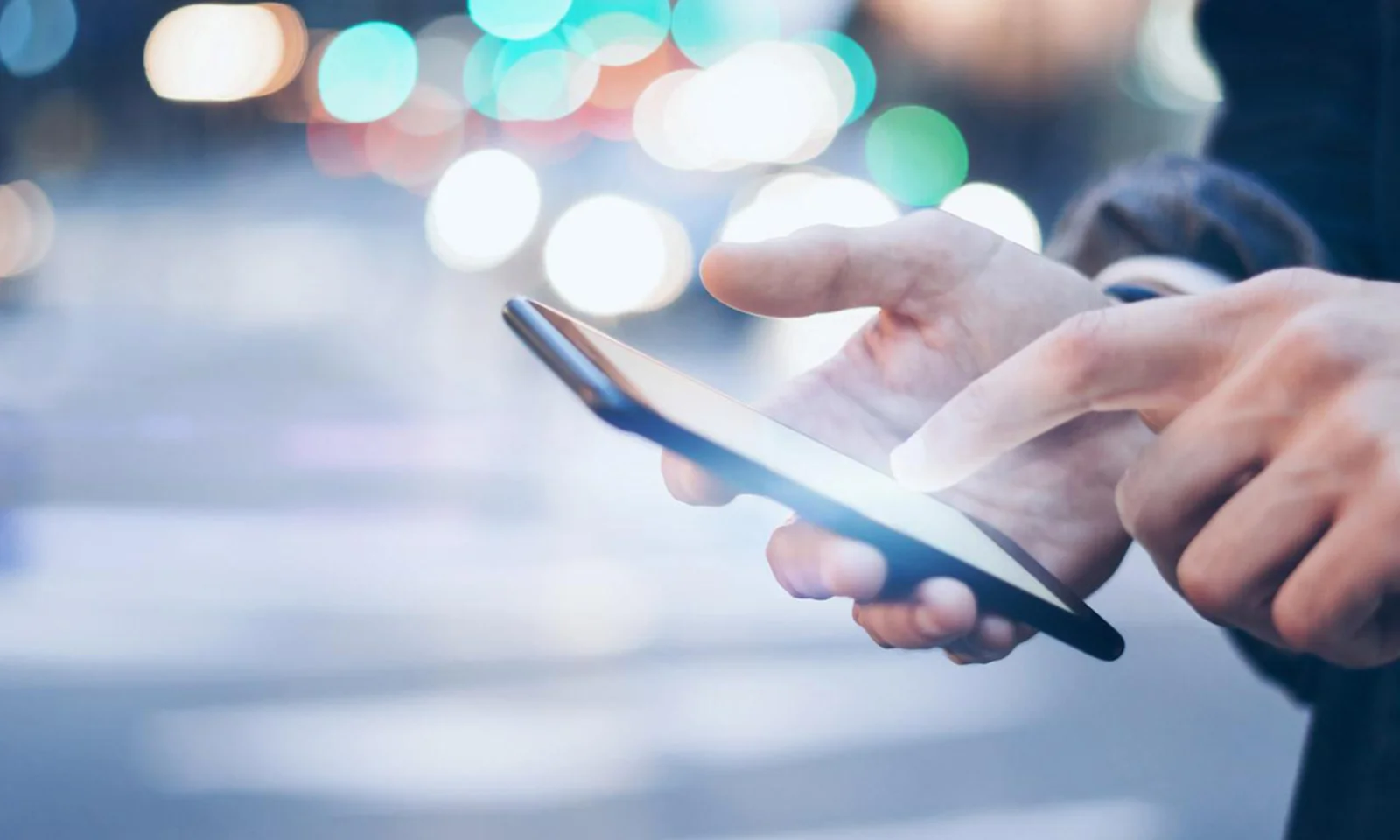 Close-up of a person using a smartphone, symbolising the integration of open banking technology by Bank Leumi.