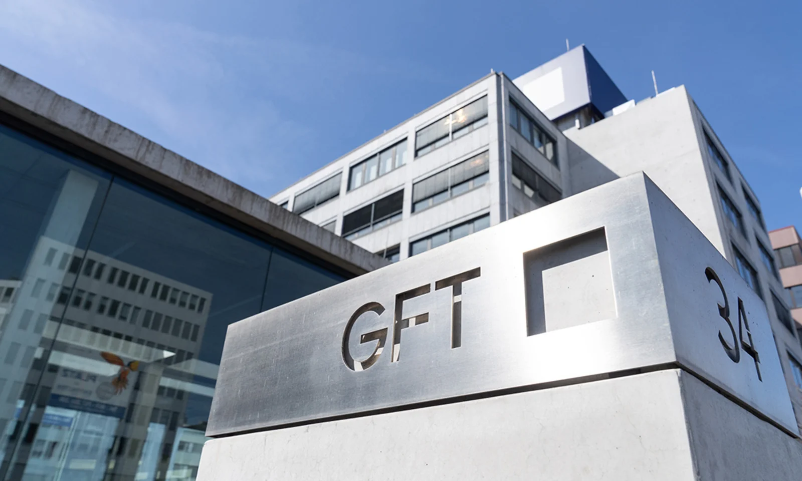 A view of the exterior of GFT&#039;s headquarters building, featuring the company&#039;s logo and modern architectural design.