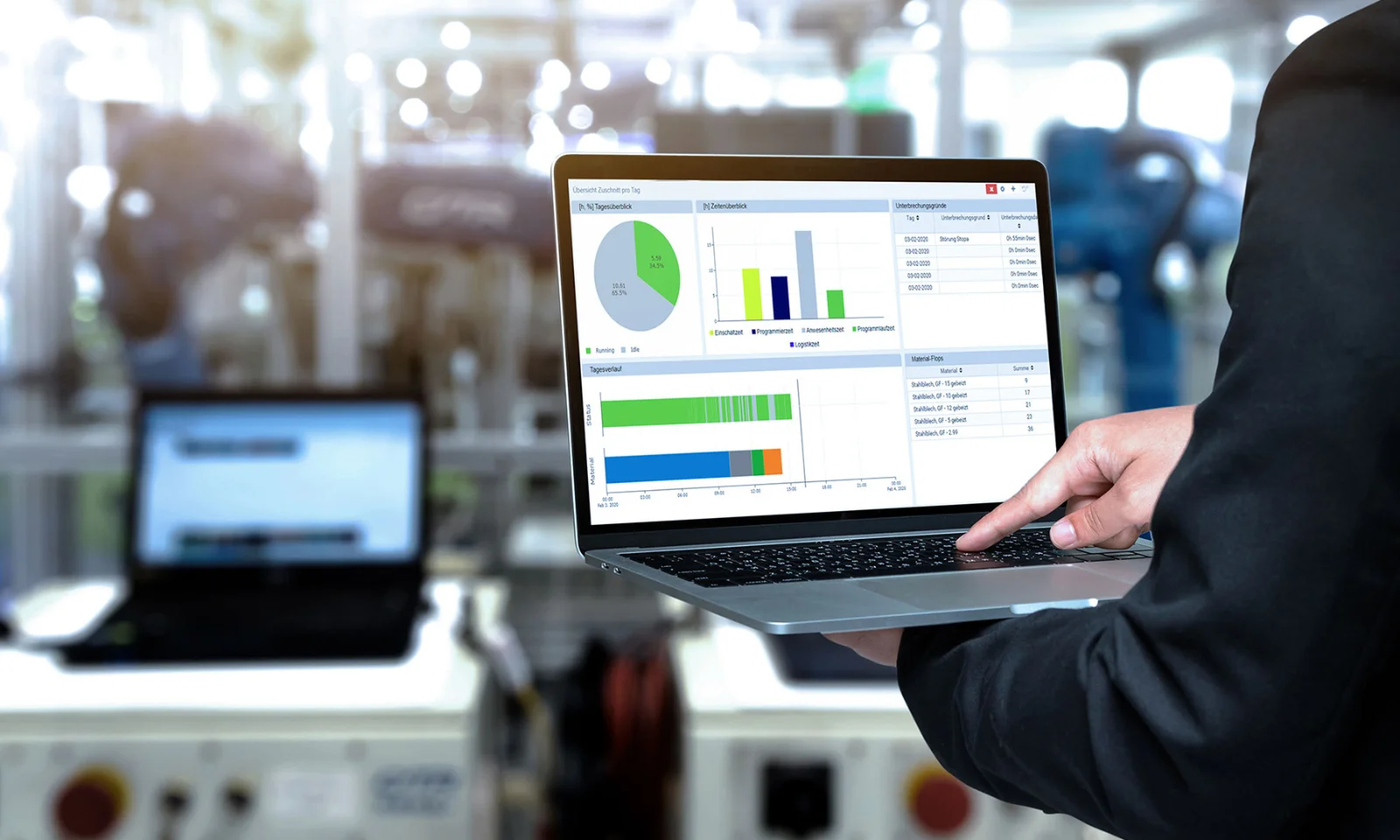 A person using a laptop to monitor and analyse shop floor data with graphs and charts, representing enhanced transparency and efficiency at Schinko.