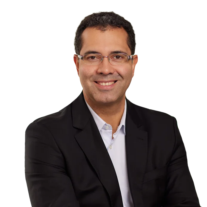 Portrait of Marco Santos in a black blazer and glasses.